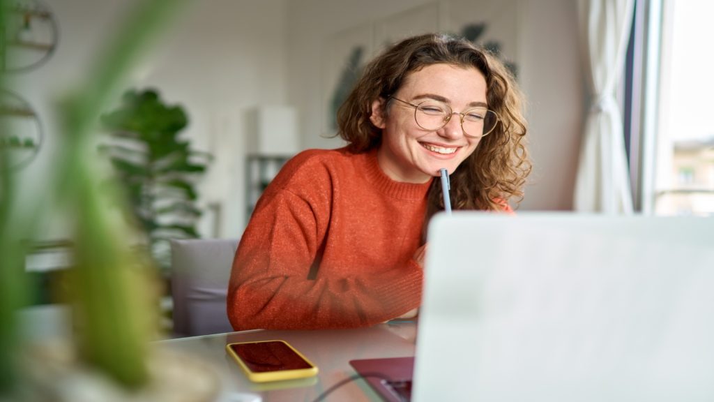 Mujer sonriendo estudiando con un portátil